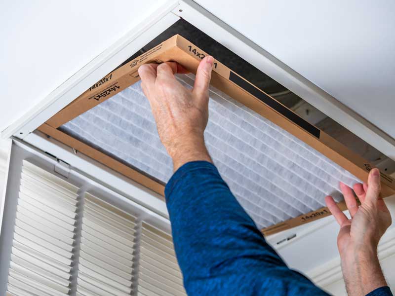 quality heating and air conditioning tech replacing-air-filter